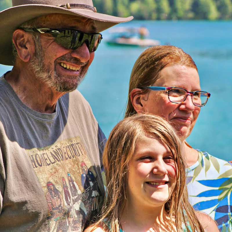 Smiling family standing by Dickey Lake in North West Montana